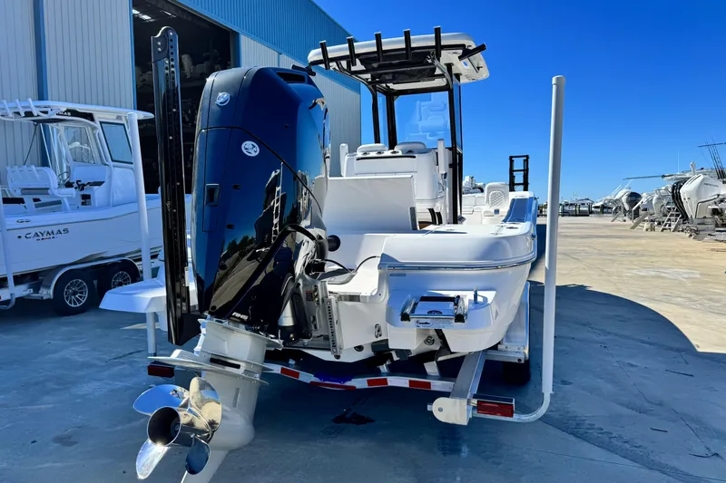 Slide: The Image of 2026 Caymas 28 HB boat with powerful outboard motor, docked at a marina under clear blue sky. - 4