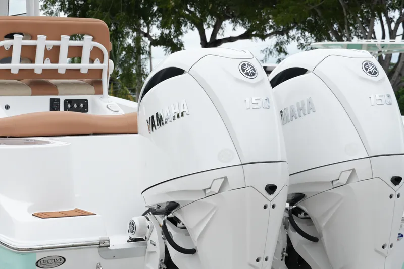 Slide: The Image of 2025 NauticStar 252 Legacy boat with dual Yamaha 150 engines, featuring tan seating. - 12