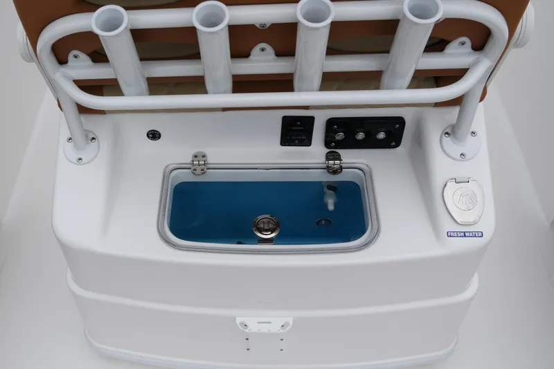 Slide: The Image of 2025 NauticStar 252 Legacy boat console with rod holders and fresh water access. - 16