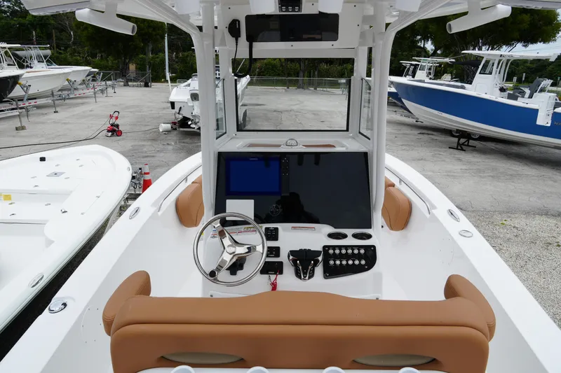 Slide: The Image of 2025 NauticStar 252 Legacy boat interior with modern helm and tan seating. - 17