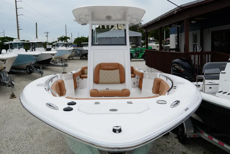 Slide: The Image of 2025 NauticStar 252 Legacy boat with tan seating, displayed outdoors. - 21