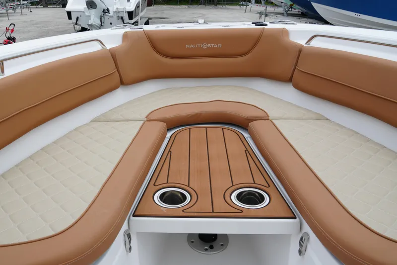 Slide: The Image of 2025 NauticStar 252 Legacy boat interior with tan seating and wood accents. - 23