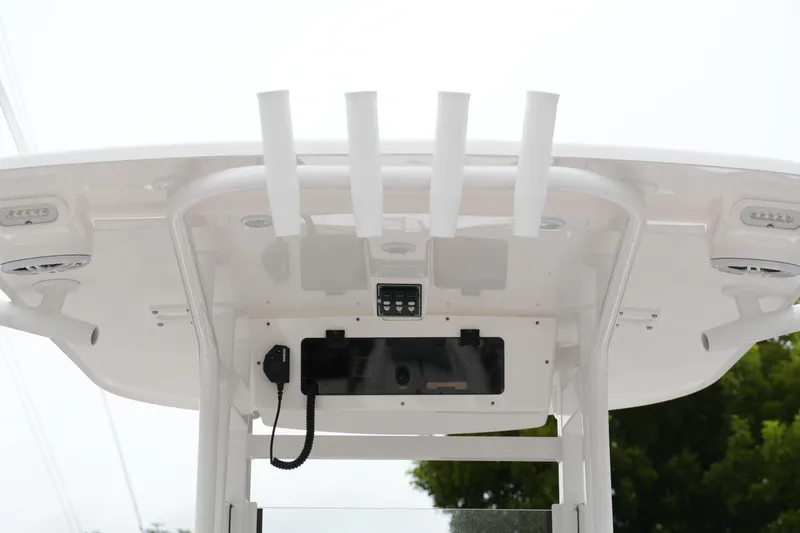 Slide: The Image of 2025 NauticStar 252 Legacy boat T-top with rod holders and electronics. - 6