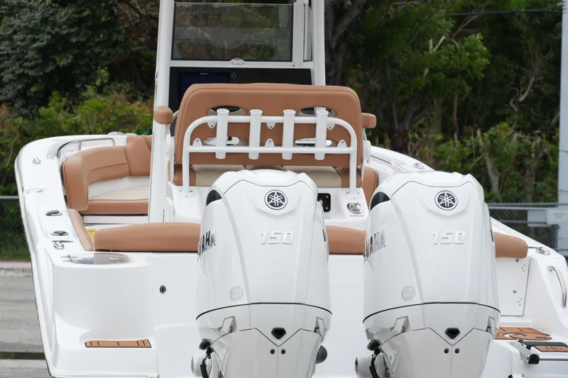 Slide: The Image of 2025 NauticStar 252 Legacy boat with dual Yamaha 150 engines, featuring tan seating. - 9