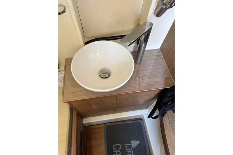 Slide: The Image of Modern bathroom sink in 2018 Chris-Craft 350 Catalina yacht, featuring sleek faucet and wooden cabinetry. - 12