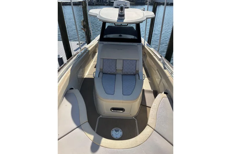 Slide: The Image of 2018 Chris-Craft 350 Catalina boat interior with cushioned seating and helm, docked by the water. - 18
