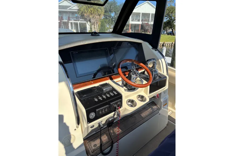 Slide: The Image of 2018 Chris-Craft 350 Catalina helm with wooden steering wheel and modern controls. - 19