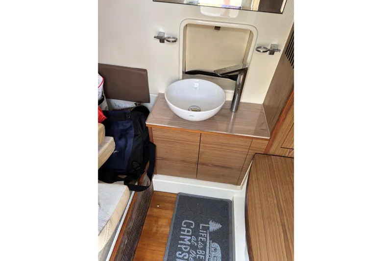 Slide: The Image of 2018 Chris-Craft 350 Catalina bathroom with modern sink and wooden cabinetry. - 5