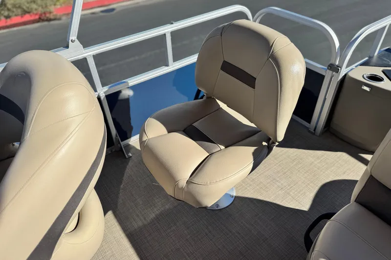 Slide: The Image of 2023 Sun Tracker Bass Buggy 18 DLX boat interior with beige seating and railing. - 18