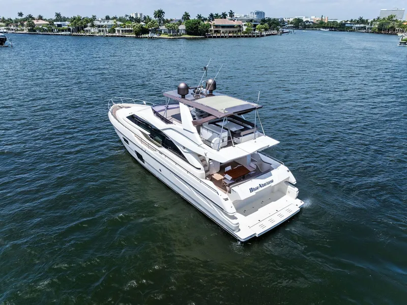 Slide: The Image of 2015 Ferretti Yachts 690 cruising on a serene waterway, surrounded by lush greenery. - 11
