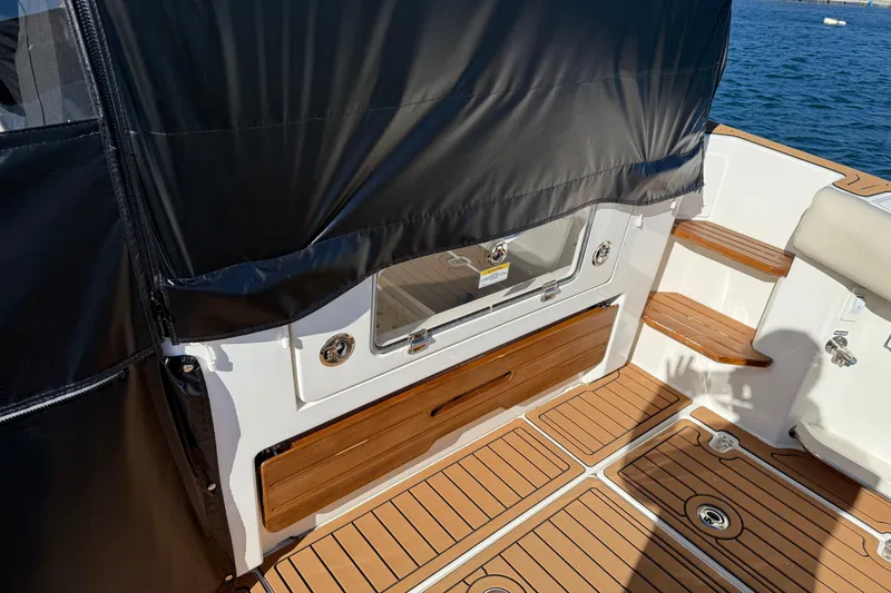 Slide: The Image of 2024 Boston Whaler 380 Realm boat deck with teak flooring and storage compartments. - 3