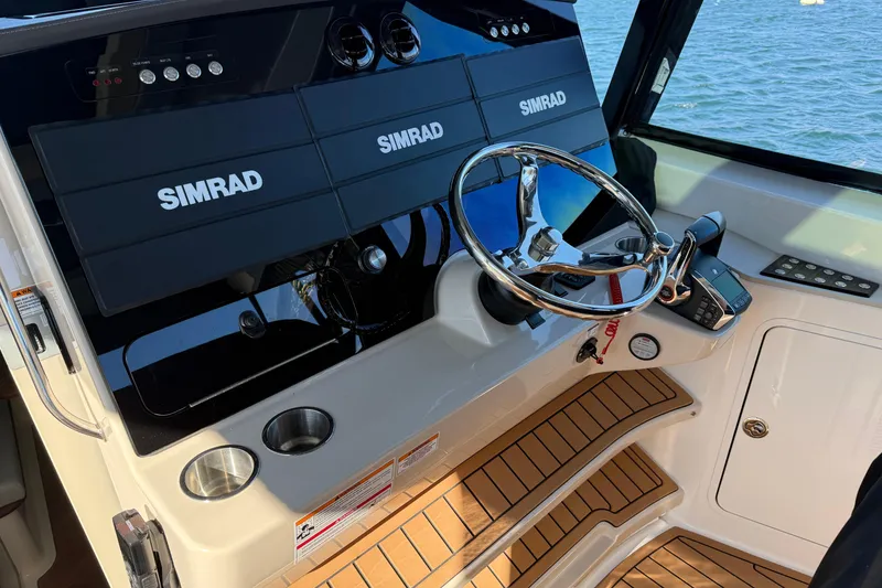 Slide: The Image of 2024 Boston Whaler 380 Realm helm with Simrad electronics and sleek steering wheel. - 5