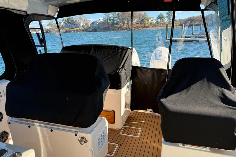 Slide: The Image of 2024 Boston Whaler 380 Realm interior with covered seats and scenic water view. - 7