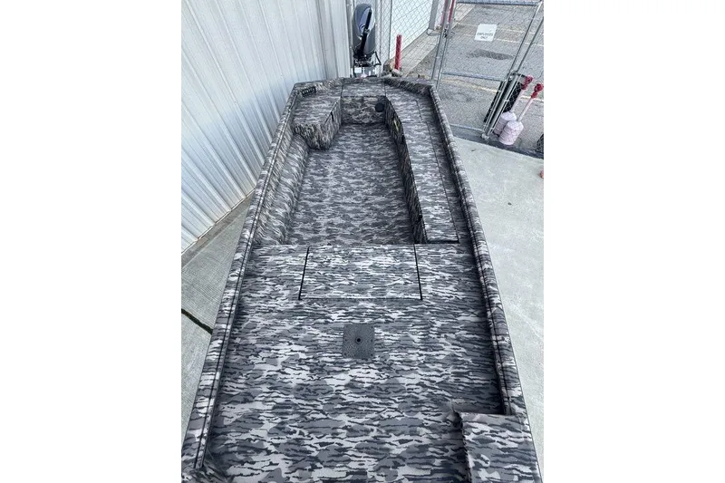 Slide: The Image of 2025 Havoc 1756 MRST boat with camouflage interior, docked near a metal fence. - 11