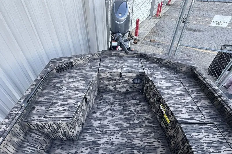 Slide: The Image of 2025 Havoc 1756 MRST boat with camouflage interior, parked near a metal fence. - 9