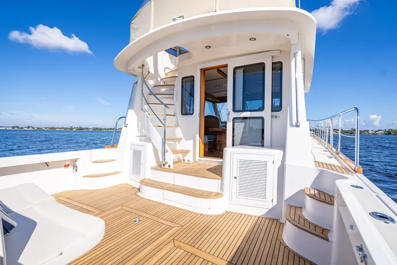 Slide: The Image of 2008 Grand Banks 47 Eastbay FB yacht deck with stairs, overlooking serene blue waters. - 11
