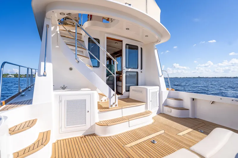 Slide: The Image of 2008 Grand Banks 47 Eastbay FB yacht deck with stairs, overlooking serene blue waters. - 13