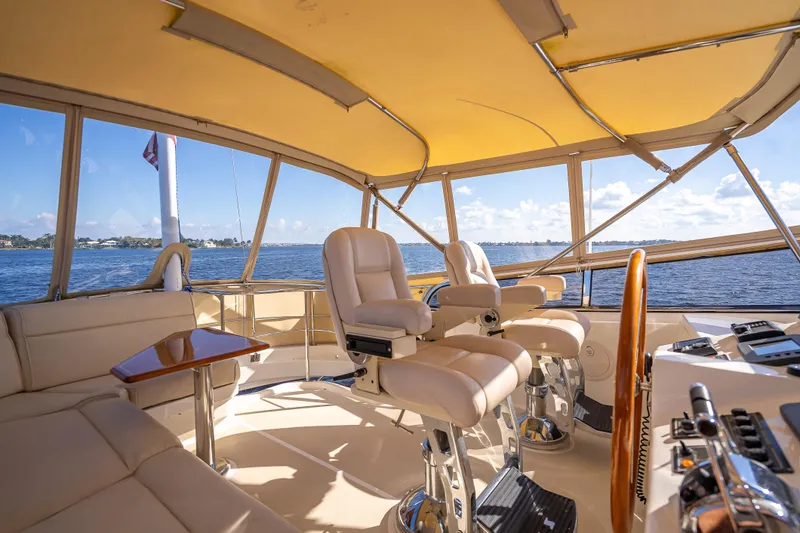 Slide: The Image of Luxurious 2008 Grand Banks 47 Eastbay FB yacht interior with helm and seating, overlooking serene waters. - 19