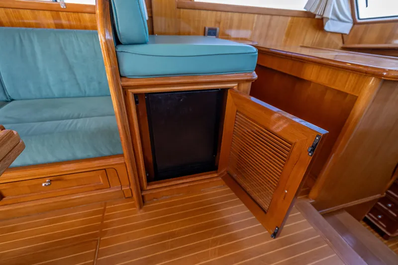 Slide: The Image of 2008 Grand Banks 47 Eastbay FB interior with open wooden cabinet and teal seating. - 39