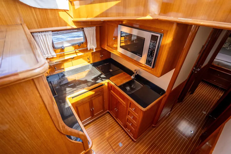 Slide: The Image of Luxurious 2008 Grand Banks 47 Eastbay FB yacht kitchen with wood cabinetry and modern appliances. - 40