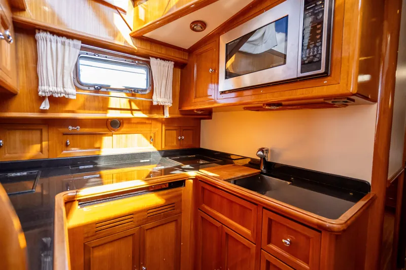 Slide: The Image of Luxurious 2008 Grand Banks 47 Eastbay FB yacht kitchen with wood cabinetry and modern appliances. - 42