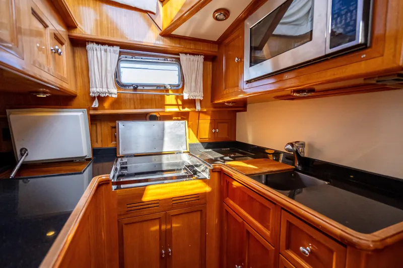 Slide: The Image of Luxurious 2008 Grand Banks 47 Eastbay FB yacht kitchen with wood cabinetry and modern appliances. - 44