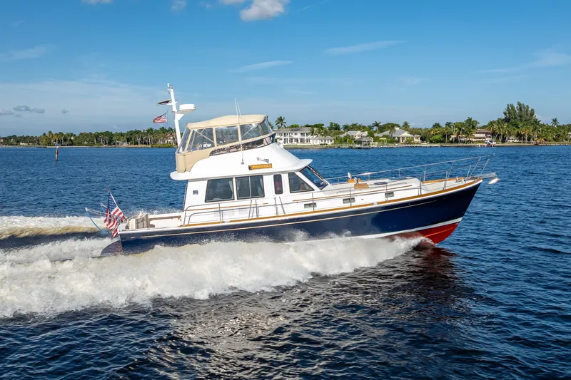 Slide: The Image of 2008 Grand Banks 47 Eastbay FB cruising on a sunny day, with coastal scenery in the background. - 5
