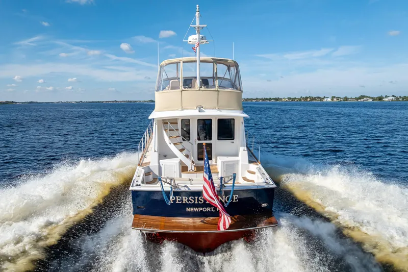 Slide: The Image of 2008 Grand Banks 47 Eastbay FB yacht cruising on open water, rear view. - 6