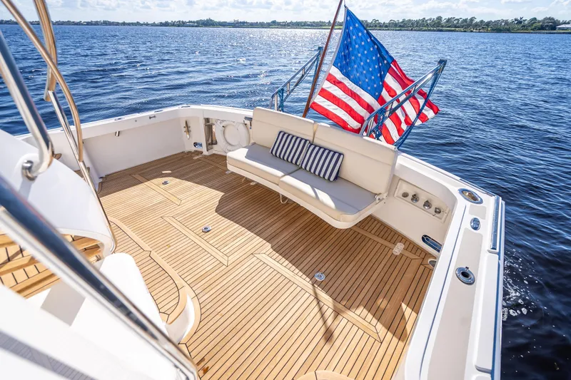 Slide: The Image of 2008 Grand Banks 47 Eastbay FB yacht with teak deck and American flag on open water. - 8