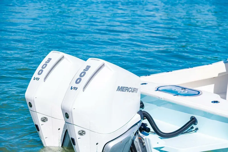 Slide: The Image of Twin Mercury 300 V8 engines on a 2022 Conch 27 boat in blue water. - 11