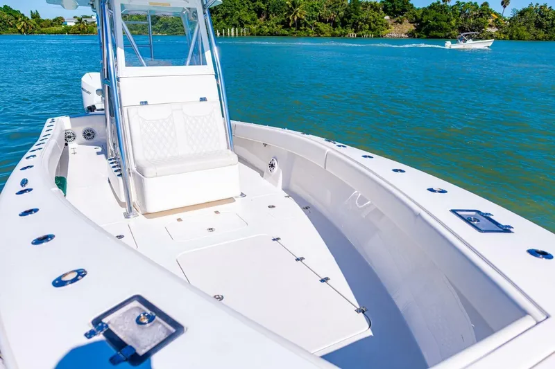 Slide: The Image of 2022 Conch 27 boat on clear blue water, featuring sleek design and spacious deck. - 13