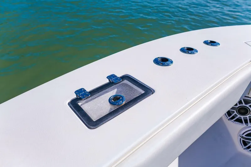 Slide: The Image of 2022 Conch 27 boat deck with rod holders and storage, on calm water. - 18