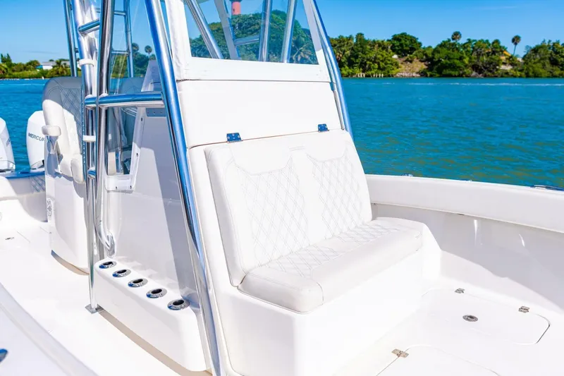 Slide: The Image of 2022 Conch 27 boat interior with white seating and stainless steel details on a sunny day. - 21