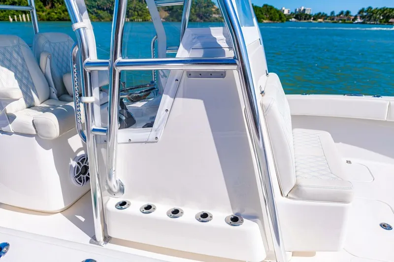 Slide: The Image of 2022 Conch 27 boat interior with white seating and chrome details, overlooking blue water. - 22