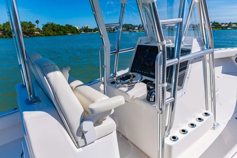 Slide: The Image of 2022 Conch 27 boat interior with steering console and seating on a sunny day. - 23