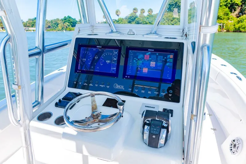Slide: The Image of 2022 Conch 27 boat dashboard with dual Simrad displays and steering wheel. - 24