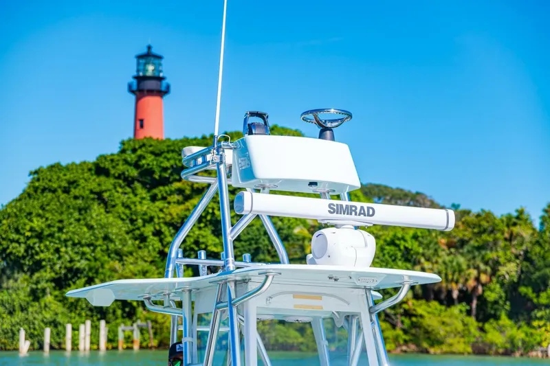 Slide: The Image of 2022 Conch 27 boat with Simrad equipment near a lighthouse and lush greenery. - 33
