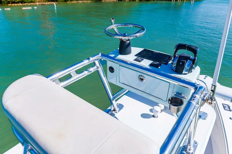 Slide: The Image of Cockpit of 2022 Conch 27 boat with steering wheel and controls on blue water. - 34