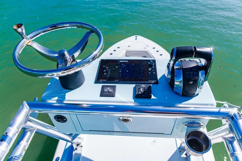 Slide: The Image of Control panel of 2022 Conch 27 boat with steering wheel and navigation system. - 35