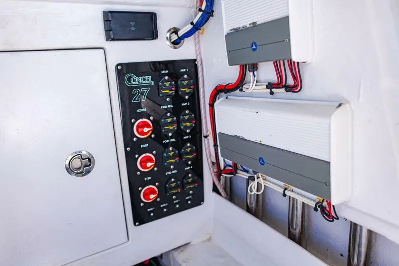 Slide: The Image of Control panel of 2022 Conch 27 boat with wiring and switches. - 39