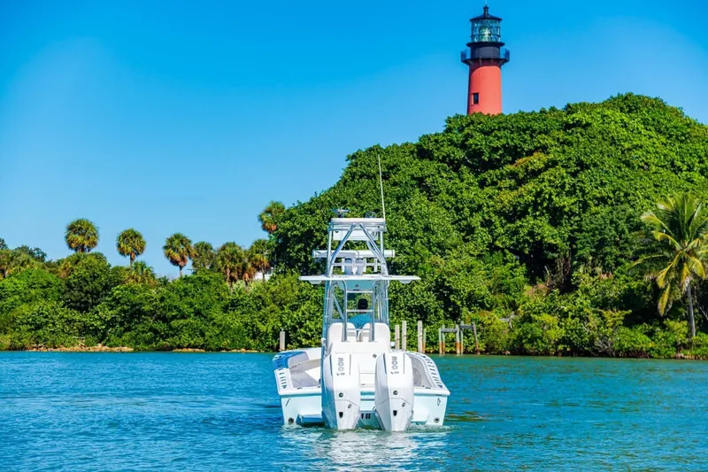 Slide: The Image of 2022 Conch 27 boat on water near lush greenery and lighthouse. - 8