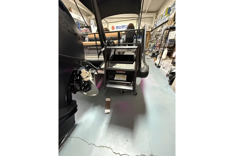 Slide: The Image of 2026 Viaggio Diamante 24S boat in showroom, featuring rear view with motor and ladder. - 26