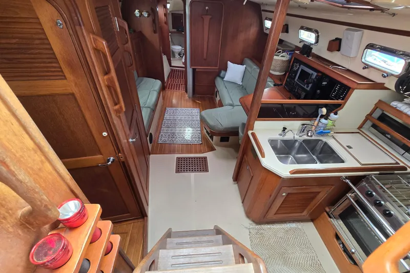 Slide: The Image of Interior of 2001 Island Packet 420 yacht with kitchen, seating, and wooden finishes. - 1