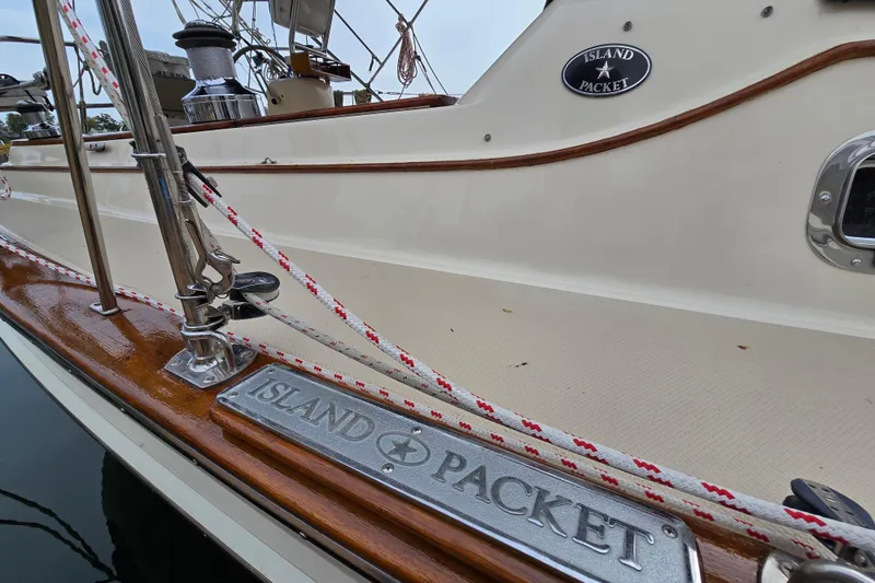 Slide: The Image of Island Packet 420 sailboat deck, showcasing polished wood and branded metal plate, 2001 model. - 14