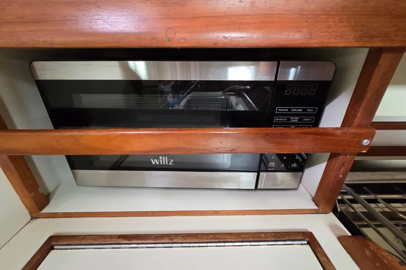 Slide: The Image of Microwave oven in 2001 Island Packet 420 yacht kitchen, surrounded by wooden cabinetry. - 43