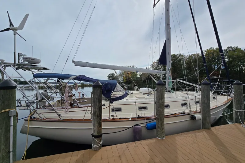 Slide: The Image of Island Packet 420 sailboat from 2001 docked at a marina, featuring a blue canopy. - 6