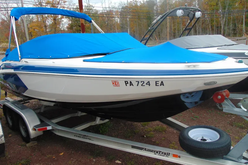 Slide: The Image of 2016 Regal 2000 ESX Bowrider with blue cover on trailer, parked outdoors. - 3