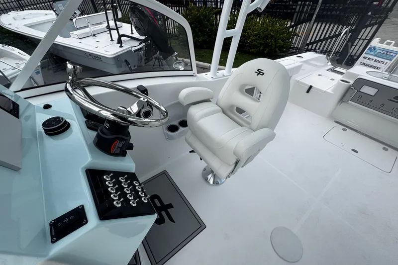 Slide: The Image of 2026 Sea Pro 240 Dual Console boat interior with steering wheel and captain's chair. - 11