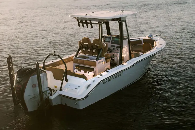 Slide: The Image of 2026 Key West 239 FSR boat with tan seating, parked outdoors near storage units. - 2