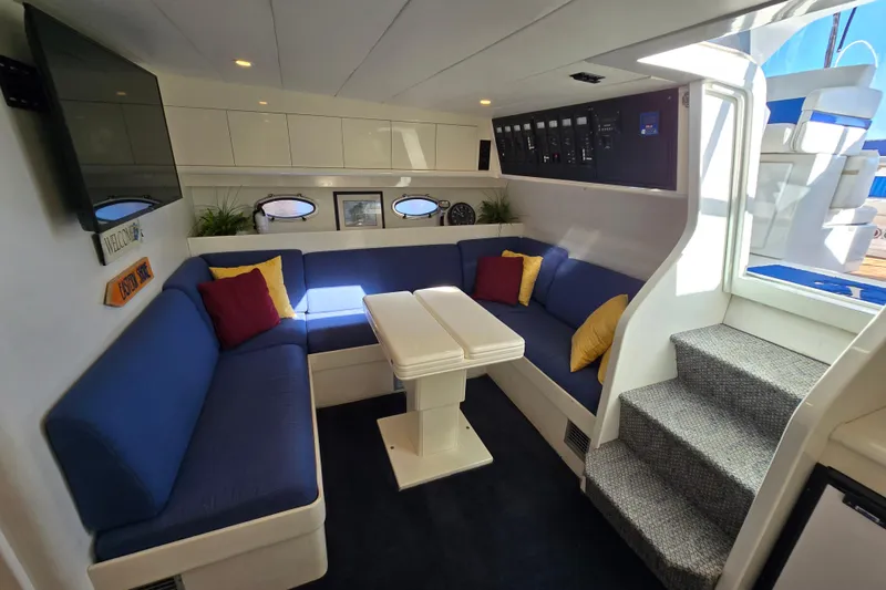 Slide: The Image of Interior of 1993 Giorgi 46 yacht with blue seating, table, and colorful cushions. - 109